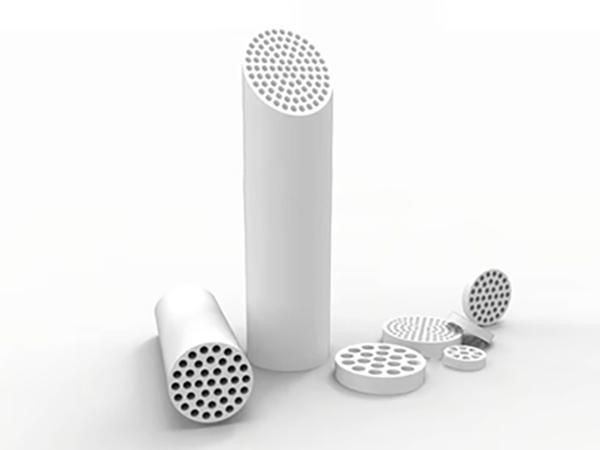 White cylindrical objects with perforated surfaces of various sizes arranged on a light background.