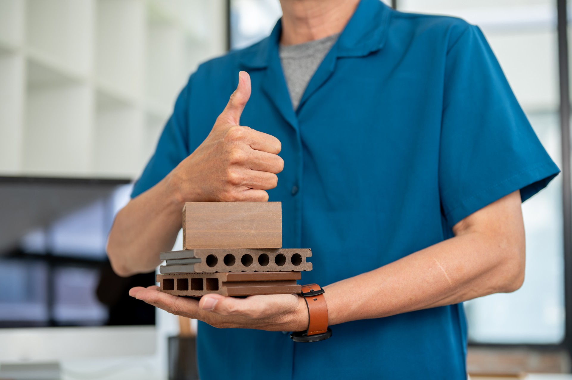 An architect or contractor holding brick material samples and showing his thumb up to the camera